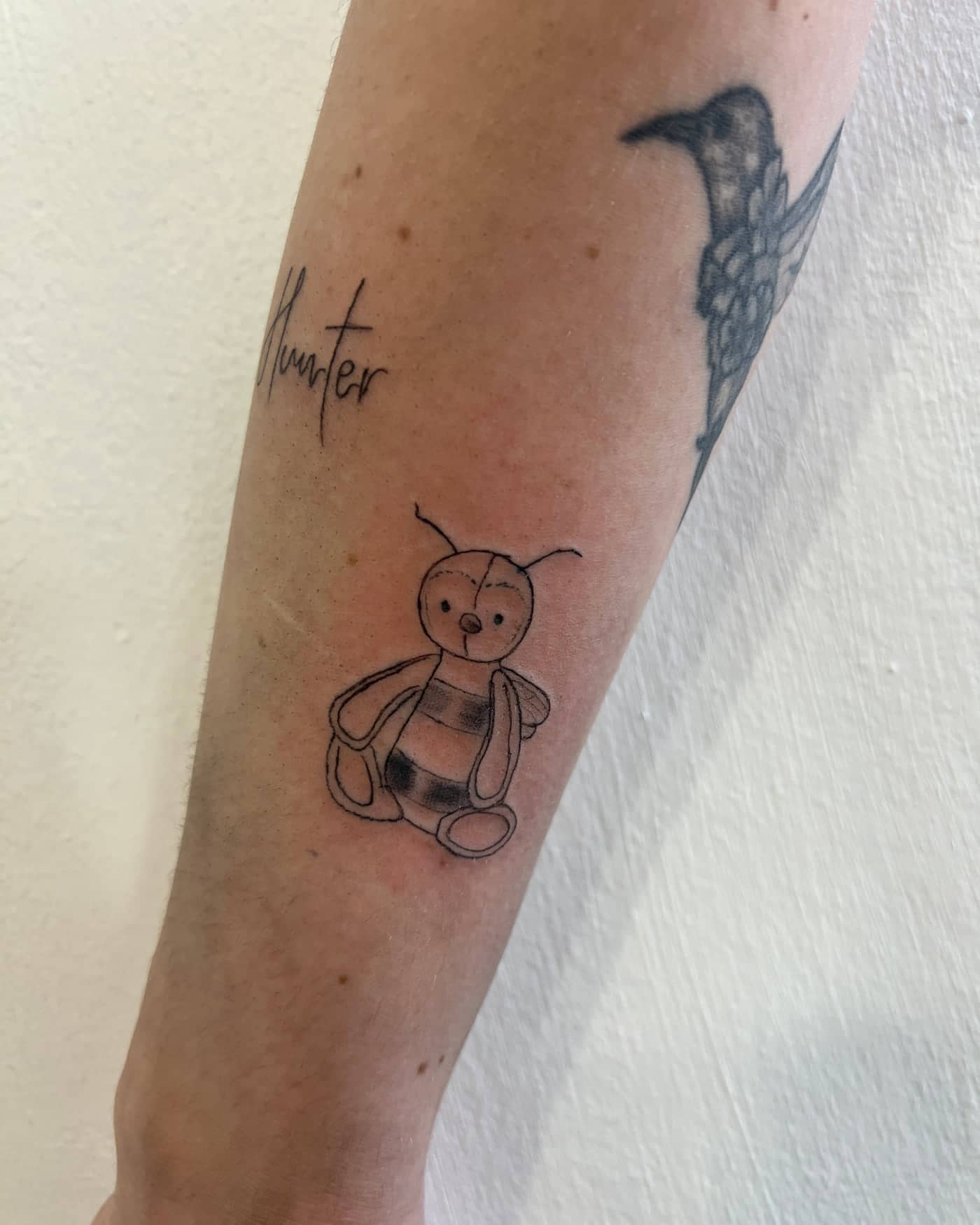 Fine line Hunter name tattoo with a bumblebee inspired by a child's first comforter