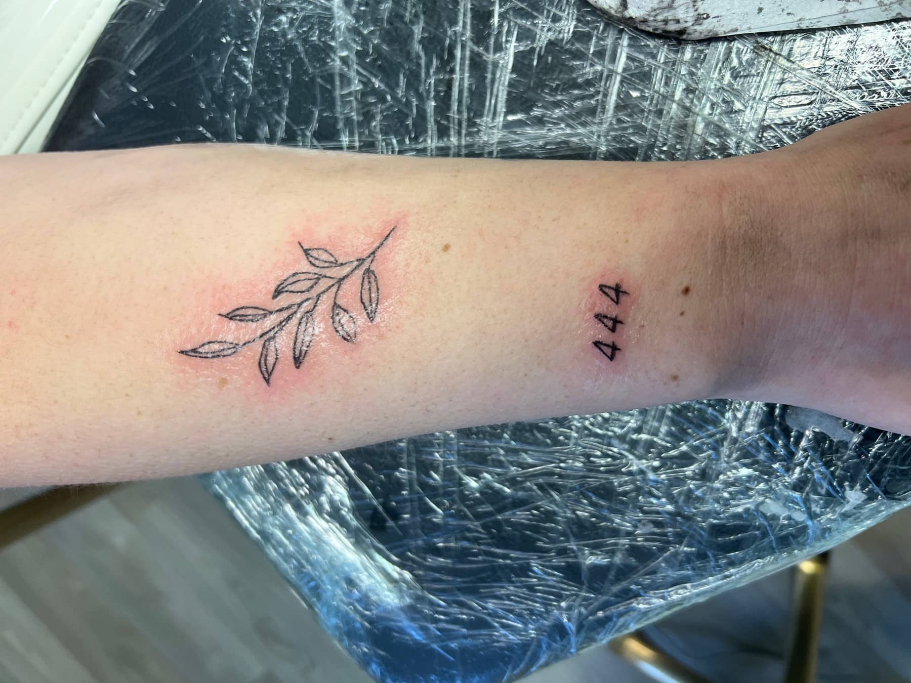 Fresh fine line leaf tattoo with small number detail