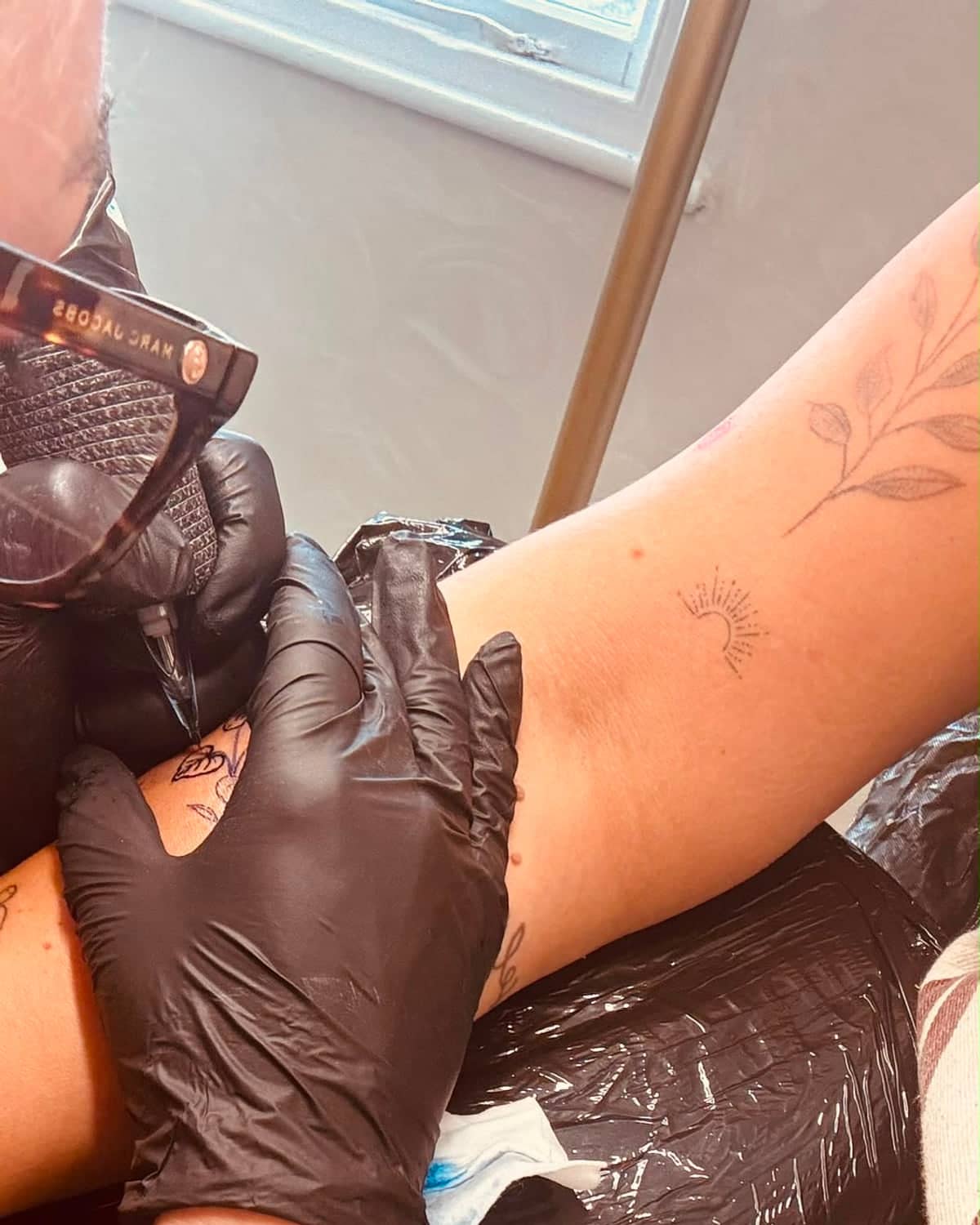 Imogen Nia tattooing a client's arm during a fine line appointment